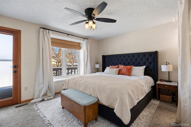 bedroom with ceiling fan, light colored carpet, and a textured ceiling