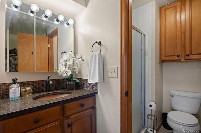 bathroom featuring vanity, walk in shower, toilet, and backsplash