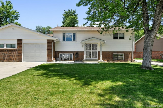 4604 Routt St, Wheat Ridge, CO 80033 - split foyer home featuring an attached garage, concrete driveway, a front yard, and brick siding