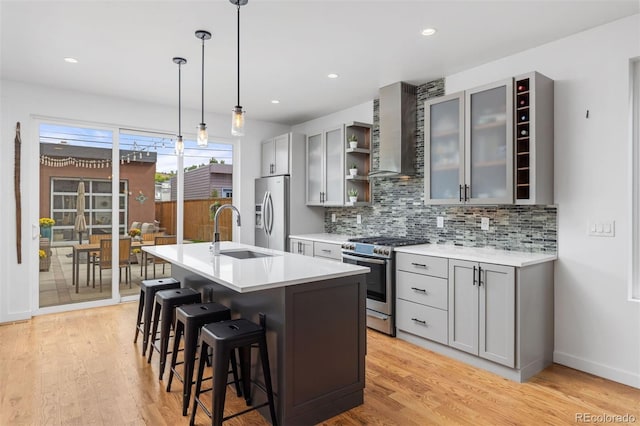 3932 Utica St, Denver, CO 80212 - kitchen featuring wall chimney range hood, appliances with stainless steel finishes, a sink, and gray cabinets