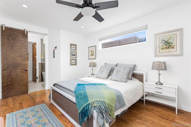 3932 Utica St, Denver, CO 80212 - bedroom with recessed lighting, a barn door, visible vents, and wood finished floors