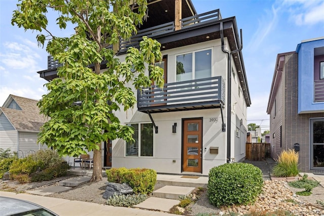 3932 Utica St, Denver, CO 80212 - view of front facade with a balcony, stucco siding, and fence