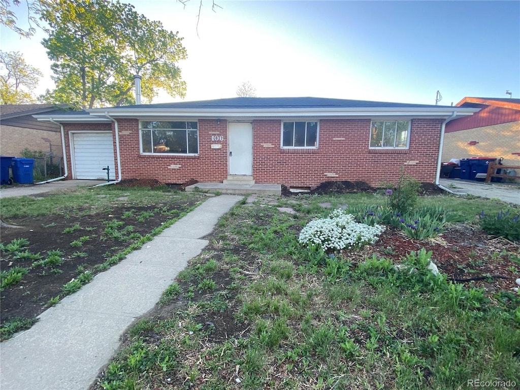 single story home with brick siding, a garage, and driveway