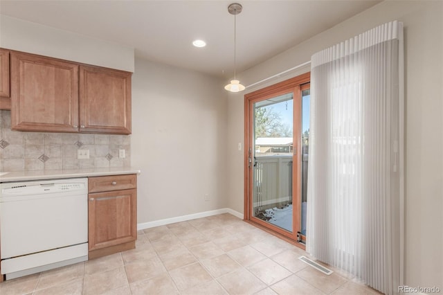 kitchen featuring white dishwasher, visible vents, hanging light fixtures, light countertops, and backsplash