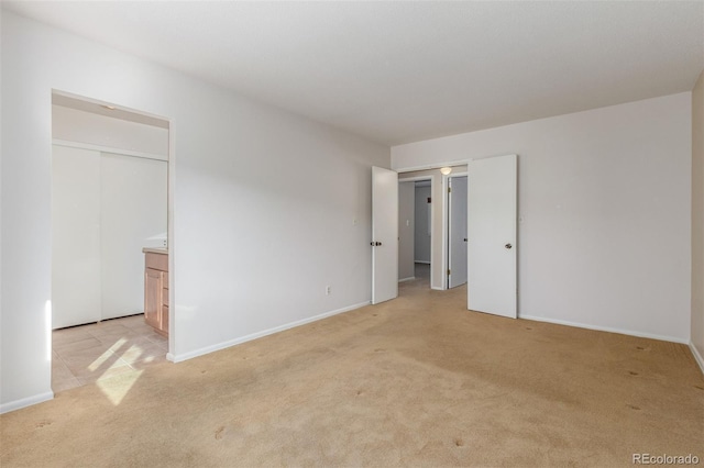 unfurnished bedroom with light carpet and baseboards