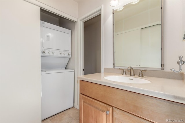 bathroom featuring stacked washer and dryer, vanity, and tile patterned floors