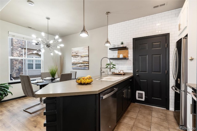 kitchen with open shelves, a sink, stainless steel appliances, a peninsula, and visible vents