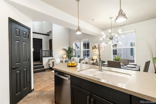 kitchen featuring hanging light fixtures, light countertops, open floor plan, light tile patterned floors, and stainless steel dishwasher