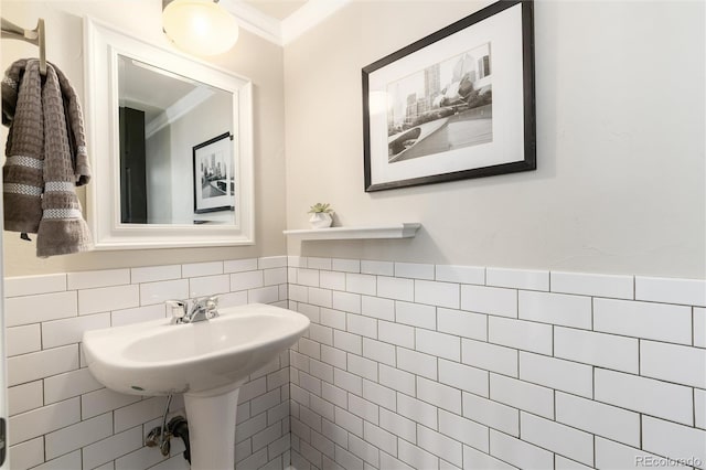 bathroom with crown molding, wainscoting, and tile walls