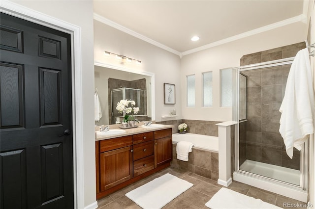 full bathroom with ornamental molding, a shower stall, a sink, and a garden tub