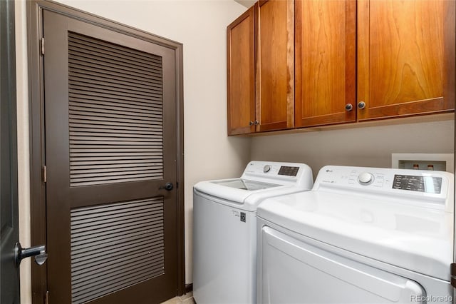 washroom with cabinet space and washer and clothes dryer