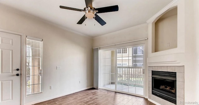 unfurnished living room with wood-type flooring, ornamental molding, a tiled fireplace, and ceiling fan