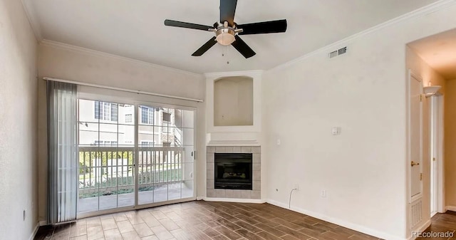 unfurnished living room with ceiling fan, a tile fireplace, dark wood-type flooring, and crown molding