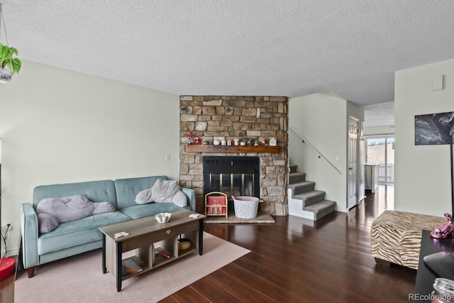 living room with wood finished floors, a textured ceiling, and a fireplace