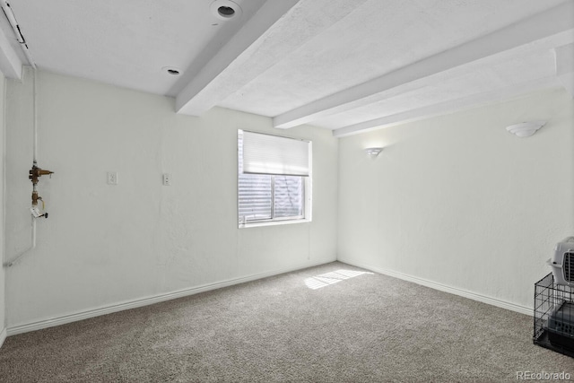unfurnished living room with beamed ceiling, carpet, and baseboards