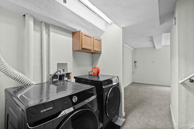 laundry area featuring washer and clothes dryer, light carpet, cabinet space, a textured wall, and baseboards