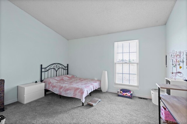 carpeted bedroom featuring a textured ceiling and vaulted ceiling