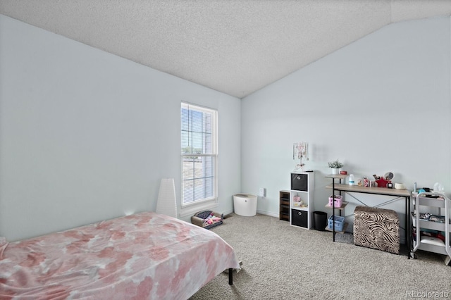 carpeted bedroom with vaulted ceiling and a textured ceiling