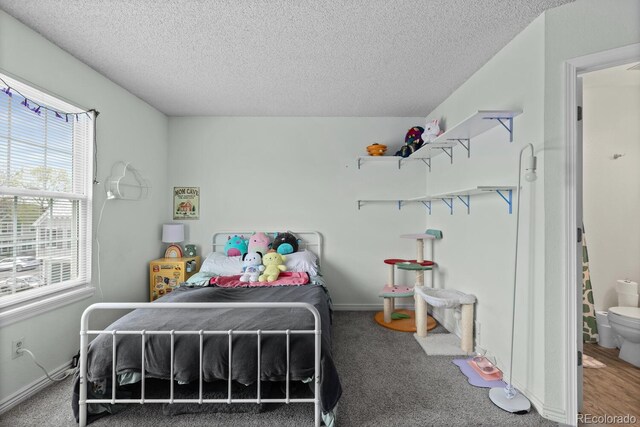 carpeted bedroom with multiple windows, a textured ceiling, and baseboards