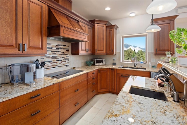 kitchen with decorative light fixtures, sink, custom range hood, and black electric stovetop