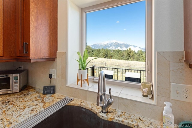 kitchen with a mountain view, tasteful backsplash, and sink