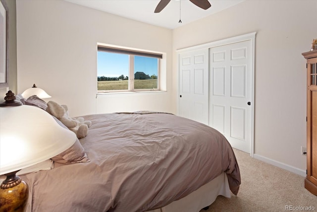 carpeted bedroom with ceiling fan and a closet