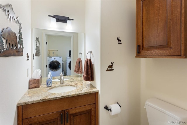 bathroom with washer and dryer, vanity, and toilet