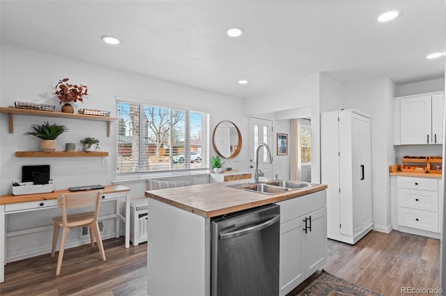 kitchen with white cabinetry, stainless steel dishwasher, sink, and a center island with sink