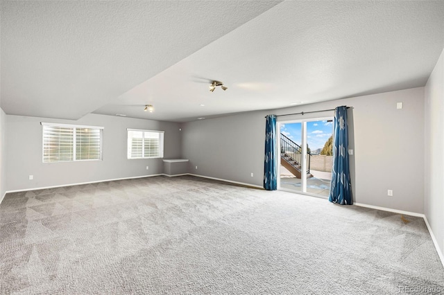 spare room with light colored carpet and a textured ceiling