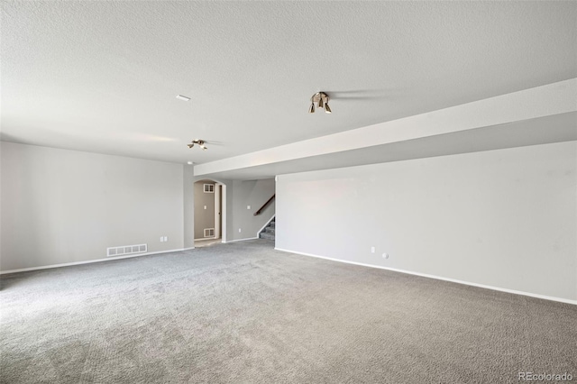 empty room featuring a textured ceiling and carpet