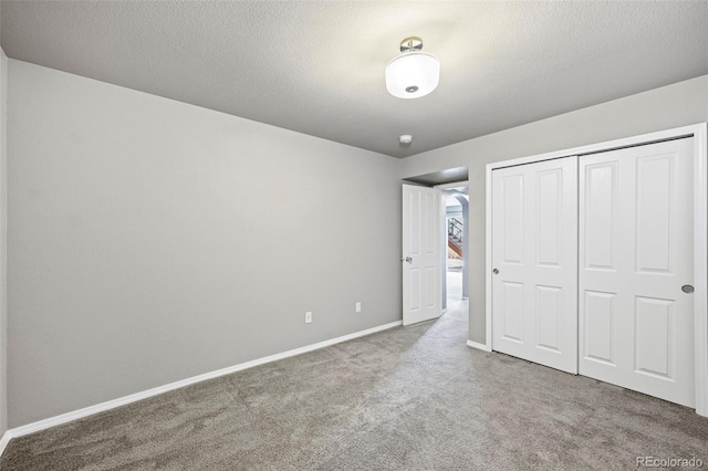 unfurnished bedroom with a closet, carpet, and a textured ceiling