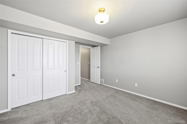 unfurnished bedroom with light colored carpet and a closet