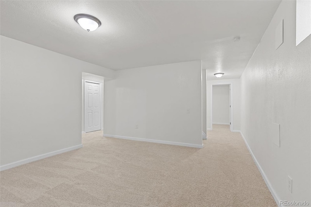 carpeted empty room featuring a textured ceiling