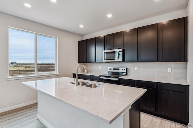 14441 Clover Dr, Mead, CO 80504 - kitchen with stainless steel appliances, a sink, light wood-type flooring, decorative backsplash, and light stone counters