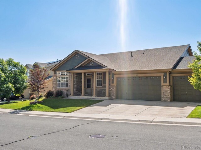 3853 S Malta St, Aurora, CO 80013 - view of front facade with a front yard, an attached garage, driveway, a porch, and brick siding