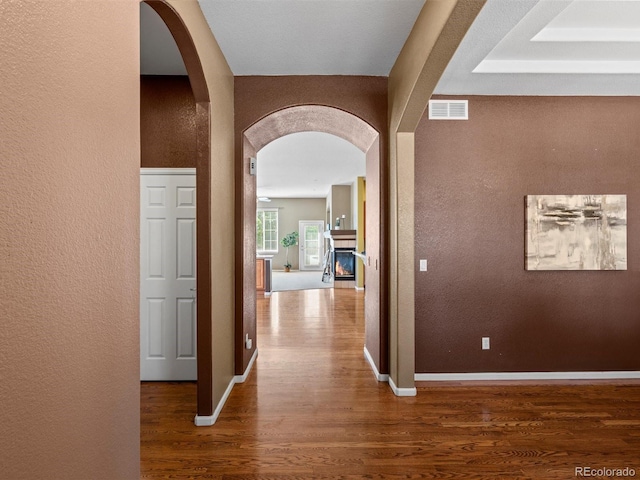3853 S Malta St, Aurora, CO 80013 - hall with a textured wall, wood finished floors, arched walkways, and baseboards