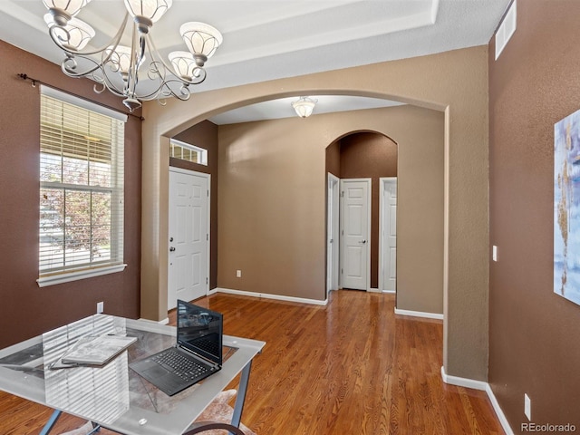 3853 S Malta St, Aurora, CO 80013 - foyer entrance with arched walkways, wood finished floors, a chandelier, and baseboards