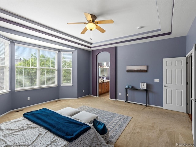 3853 S Malta St, Aurora, CO 80013 - bedroom featuring a raised ceiling, light colored carpet, arched walkways, a ceiling fan, and ensuite bath