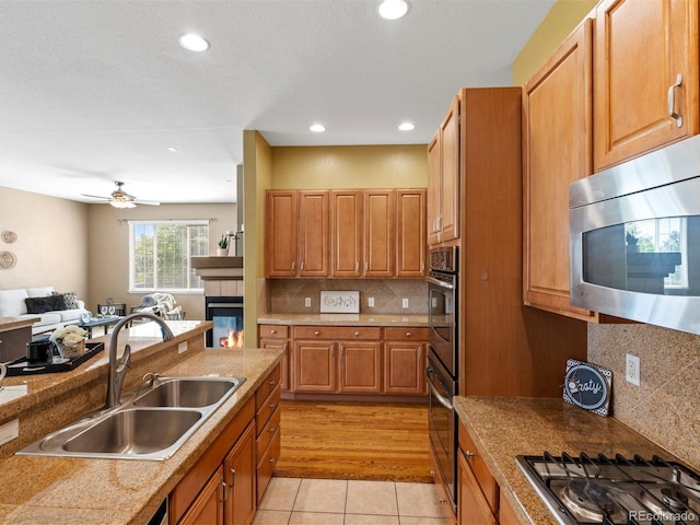 3853 S Malta St, Aurora, CO 80013 - kitchen with appliances with stainless steel finishes, a sink, open floor plan, light tile patterned floors, and backsplash