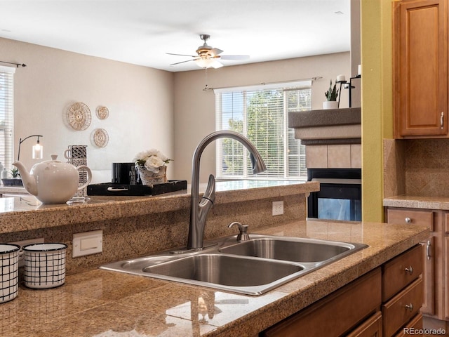 3853 S Malta St, Aurora, CO 80013 - kitchen with a sink, a ceiling fan, a fireplace, and tile countertops