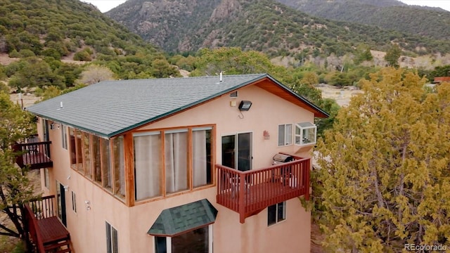 4236 Tranquil Way, Crestone, CO 81131 - back of house with a mountain view, stucco siding, and a balcony