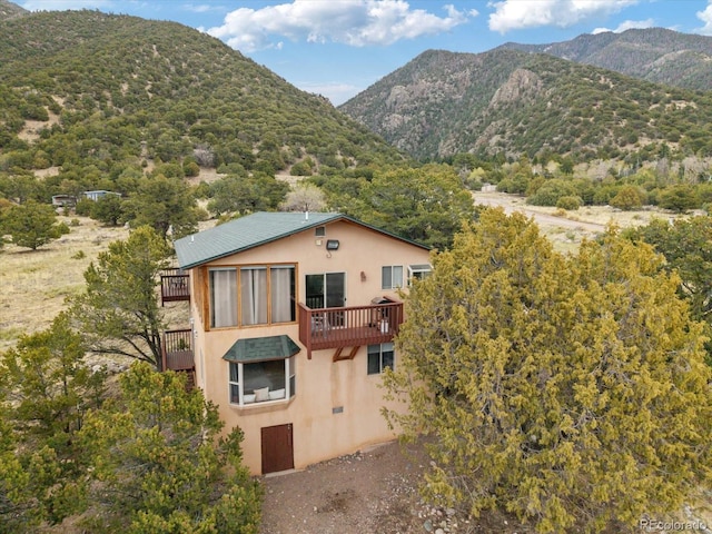 4236 Tranquil Way, Crestone, CO 81131 - exterior space with stucco siding, a deck with mountain view, and a balcony