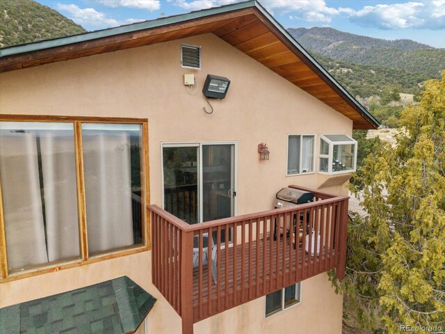 4236 Tranquil Way, Crestone, CO 81131 - back of property with visible vents, a mountain view, stucco siding, and a balcony