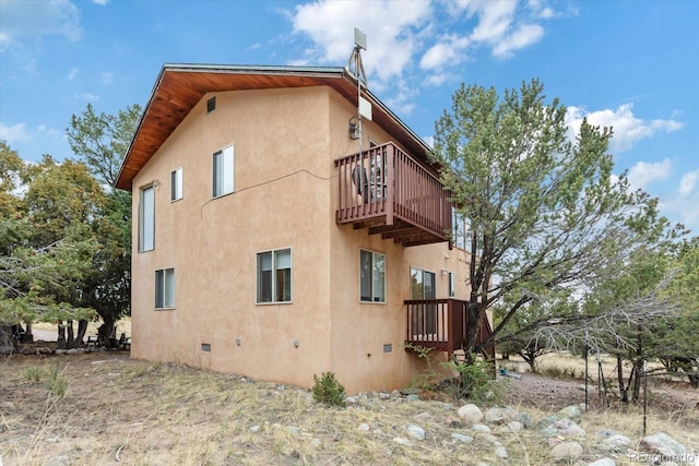 4236 Tranquil Way, Crestone, CO 81131 - view of property exterior with stucco siding, a balcony, and crawl space