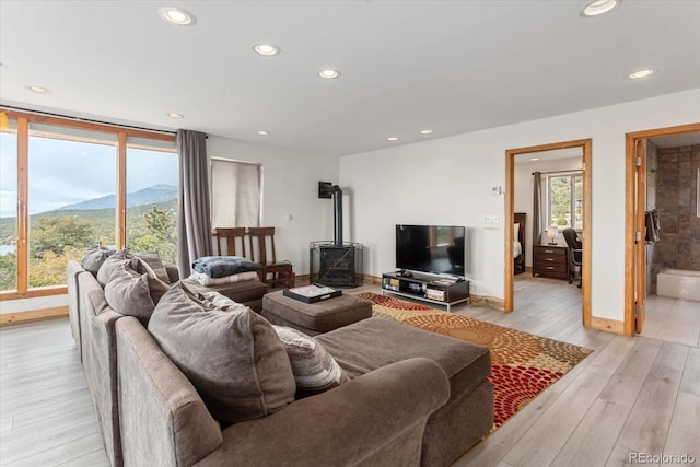 4236 Tranquil Way, Crestone, CO 81131 - living room featuring a wood stove, light wood-style floors, recessed lighting, baseboards, and a mountain view