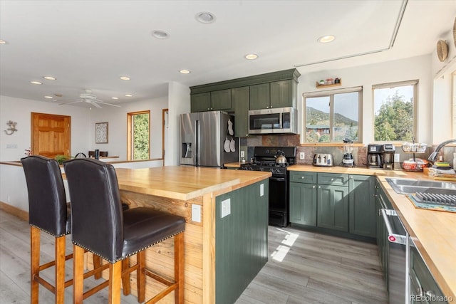 4236 Tranquil Way, Crestone, CO 81131 - kitchen with appliances with stainless steel finishes, butcher block countertops, a sink, and green cabinetry