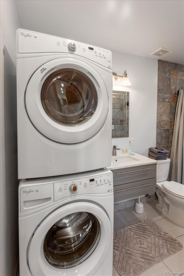 4236 Tranquil Way, Crestone, CO 81131 - laundry room with laundry area, a sink, tile patterned floors, visible vents, and stacked washer and clothes dryer