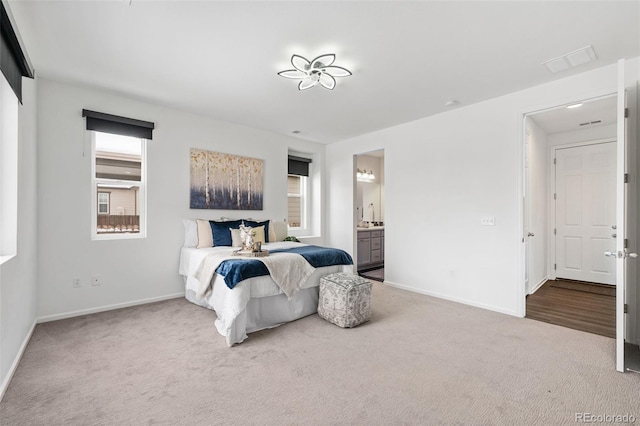 bedroom featuring ensuite bathroom and carpet