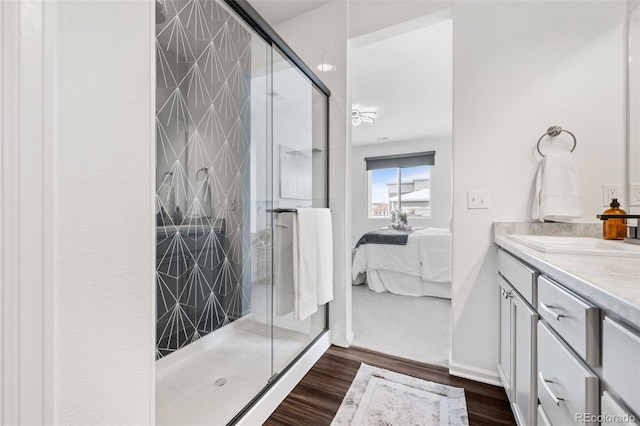 bathroom with vanity, hardwood / wood-style floors, and a shower with shower door