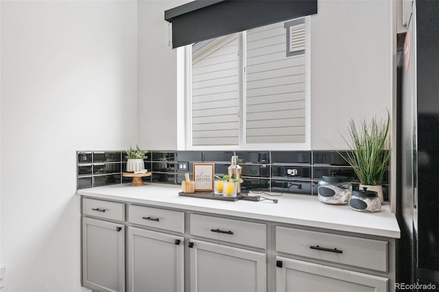 bar with stainless steel fridge and backsplash